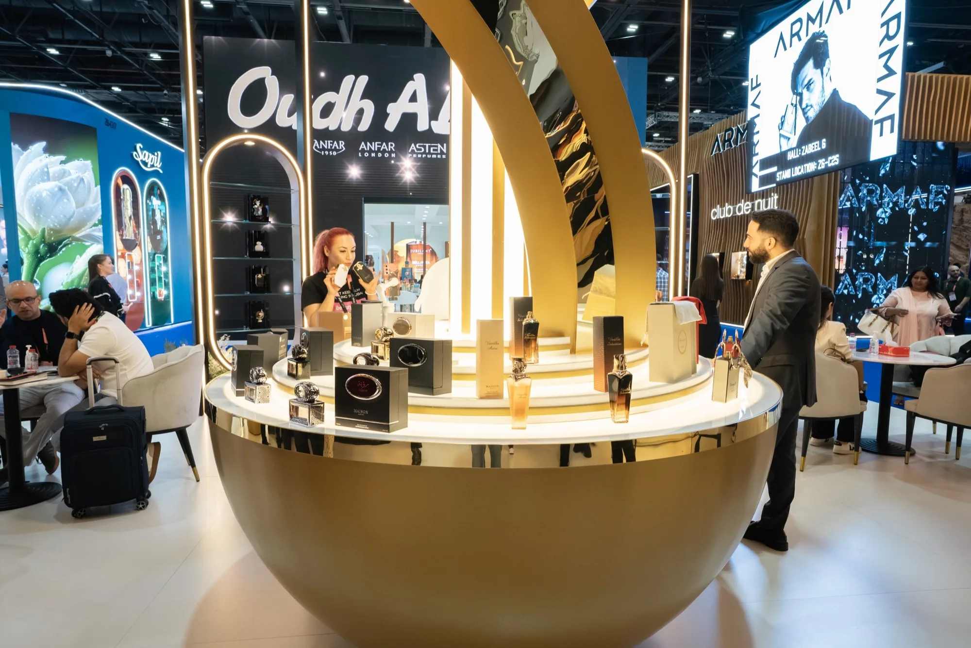 A brand ambassador presenting a fragrance to a visitor on a Beauty Sky stand